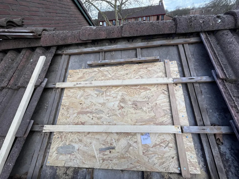 Plaatselijk hersteld dakbeschot met nieuwe panlatten op een pannendak