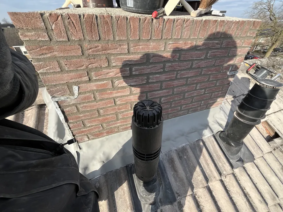 Vernieuwd loodwerk en doorvoeren rond een schoorsteen na onderhoud